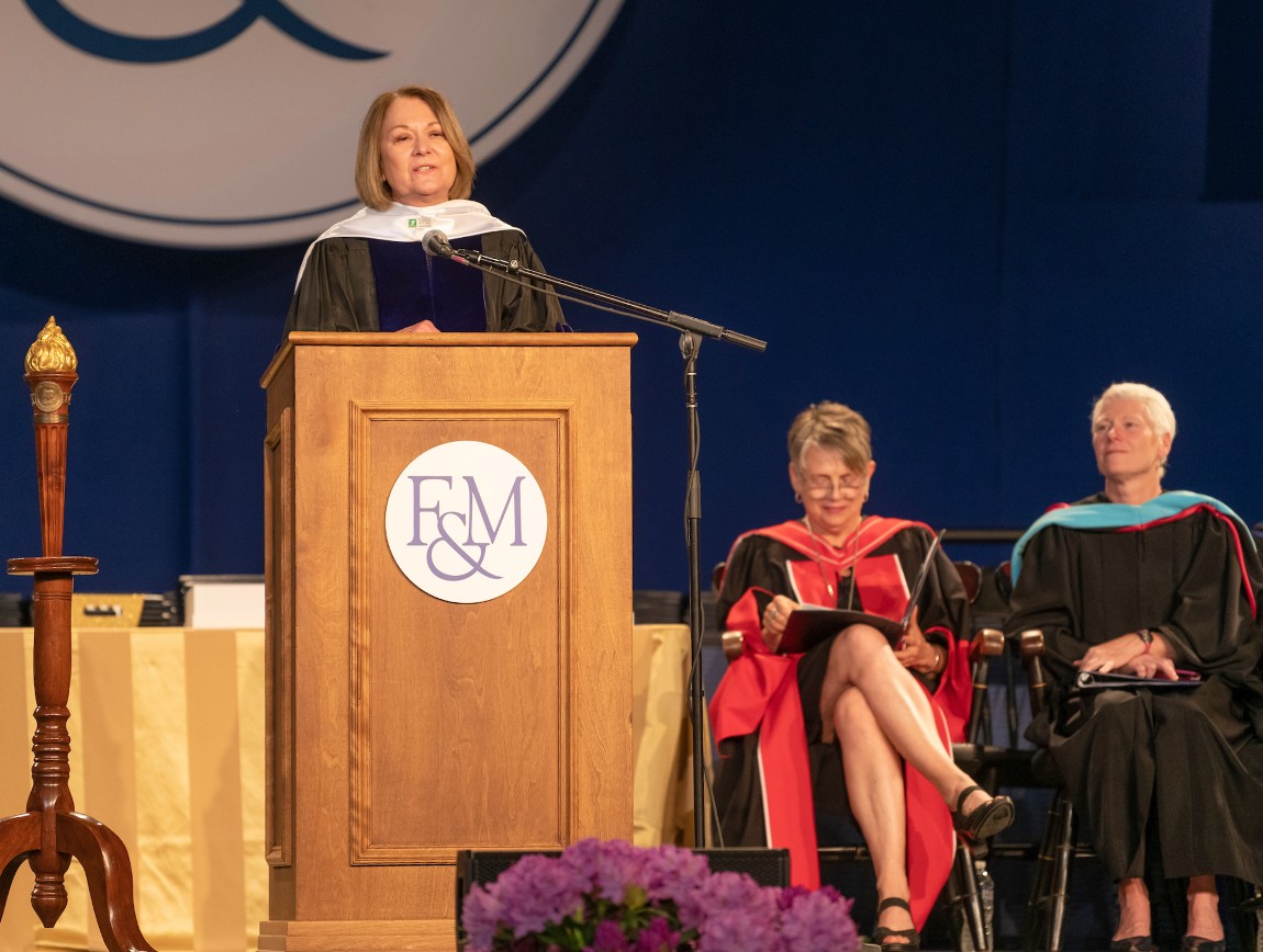 Muhlnberg College President Harring is on a stage receiving a honorary degree from F&M